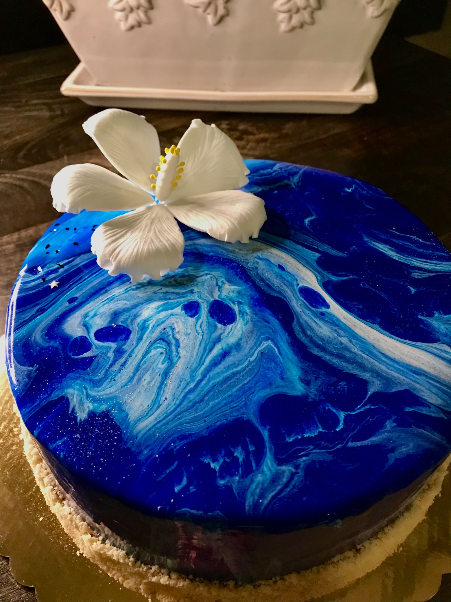 Blue marbled glaze cake with a sculpted white flower