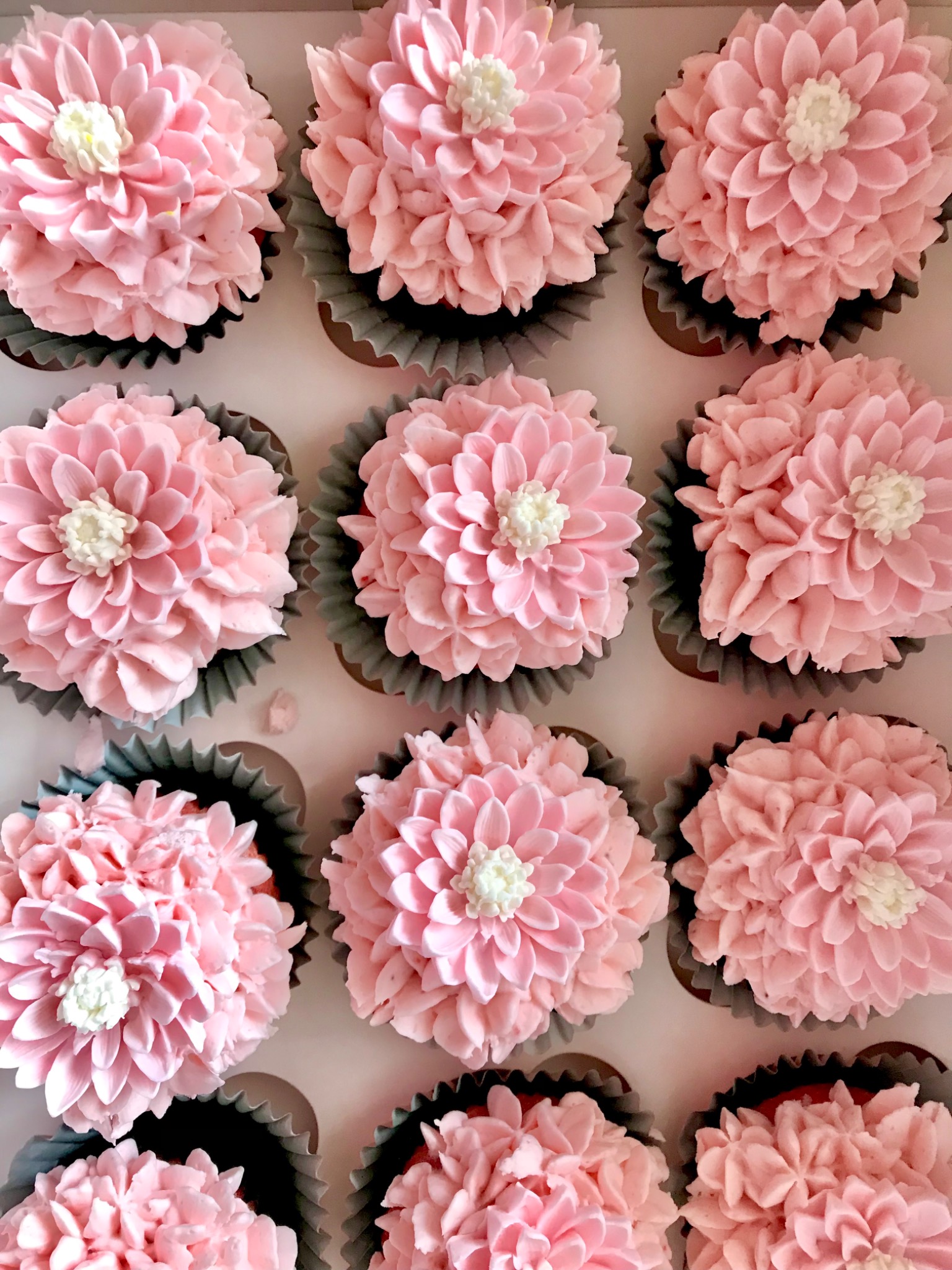 Pink floral cupcakes arranged as an edible garden